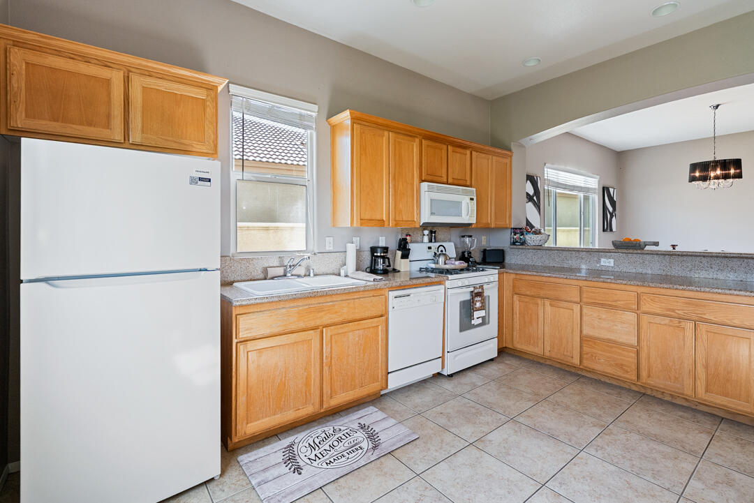 49418 Wayne Street Indio, CA 92201 - Photo 6 of 22 a kitchen with stainless steel appliances granite countertop a refrigerator sink and cabinets