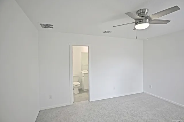 a bathroom with a toilet sink vanity and mirror