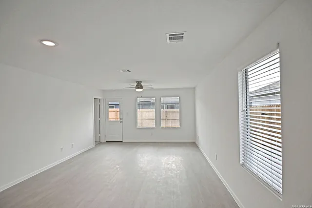 an empty room with window and ceiling fan