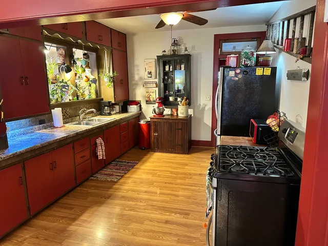 a large kitchen with stainless steel appliances kitchen island granite countertop a sink stove and refrigerator