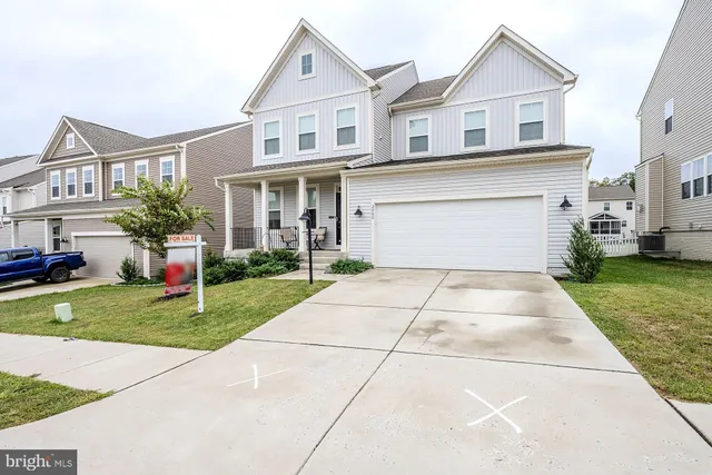 a front view of a house with a yard and potted plants