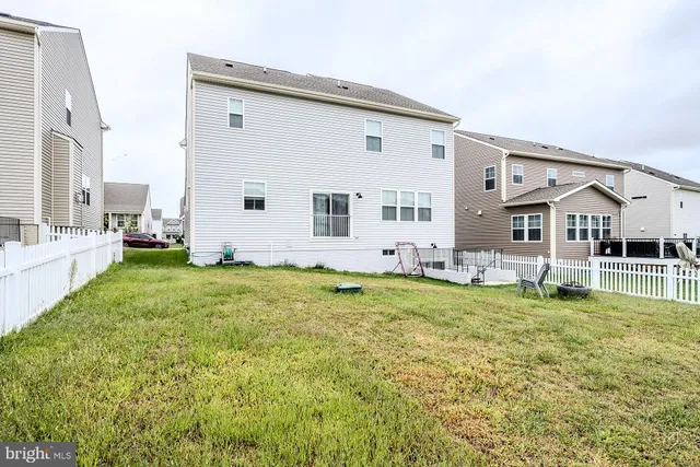 a large white house with a large pool and lawn chairs