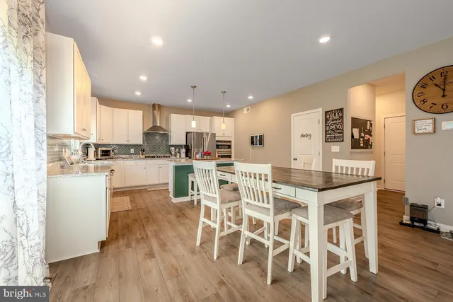 a kitchen with stainless steel appliances kitchen island granite countertop a refrigerator and a stove top oven