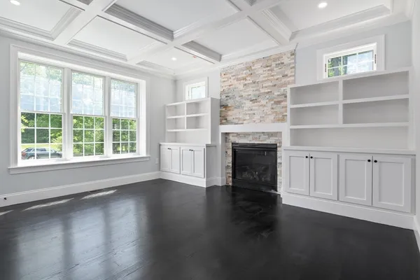 an empty room with wooden floor cabinet and a fireplace