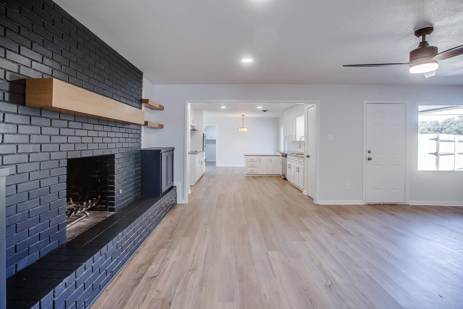 3410 53rd Street Lubbock, TX 79413 - Photo 3 of 14 a view of empty room with wooden floor and fireplace