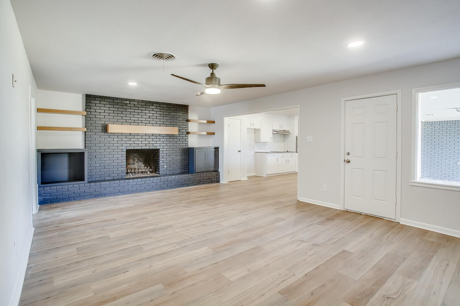 3410 53rd Street Lubbock, TX 79413 - Photo 4 of 14 an empty room with wooden floor fireplace and windows