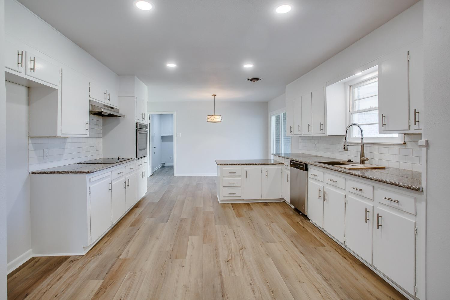 3410 53rd Street Lubbock, TX 79413 - Photo 6 of 14 a large kitchen with granite countertop a large counter top a sink stainless steel appliances and cabinets