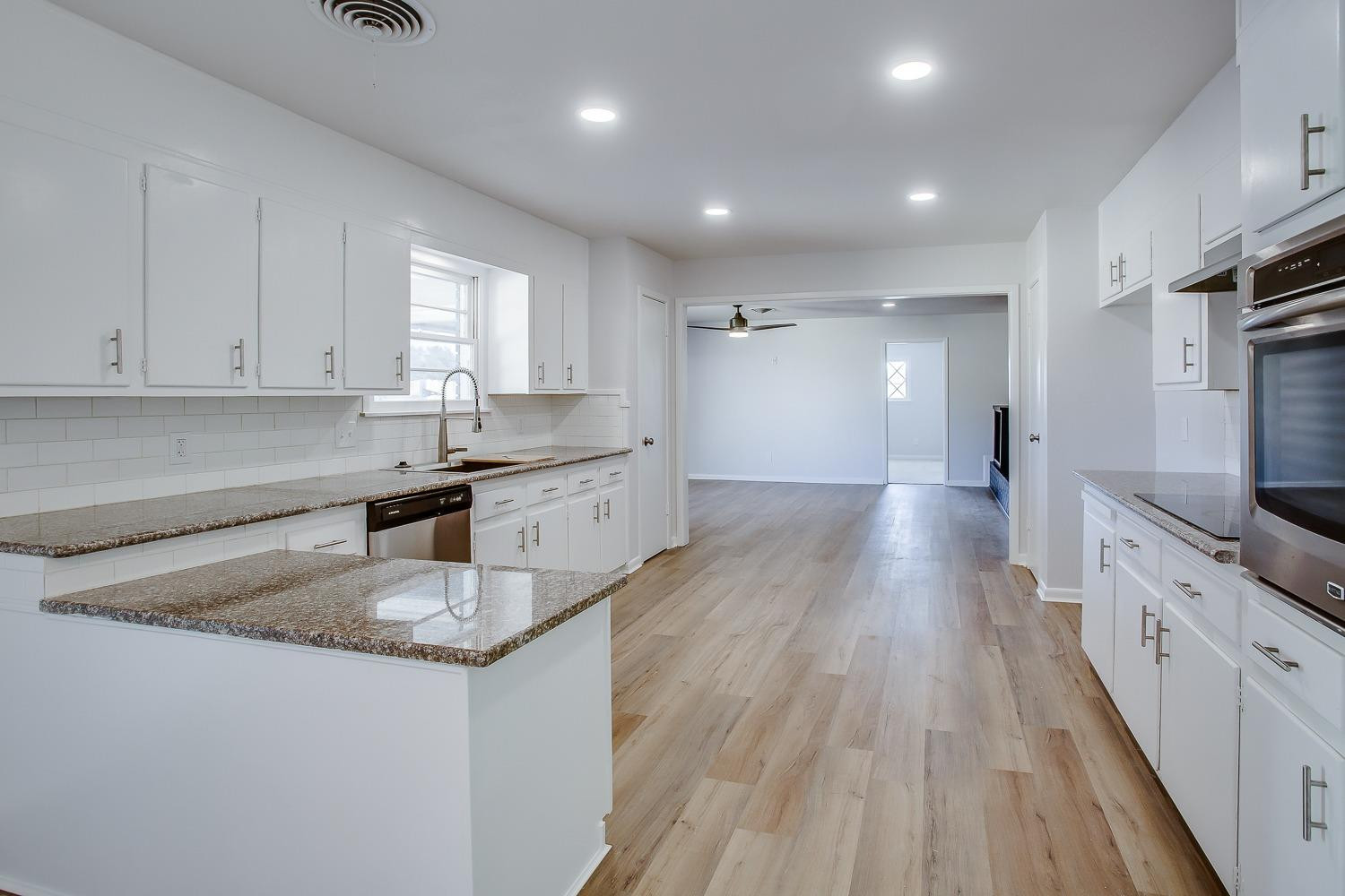 3410 53rd Street Lubbock, TX 79413 - Photo 7 of 14 a kitchen with granite countertop a sink stove and cabinets