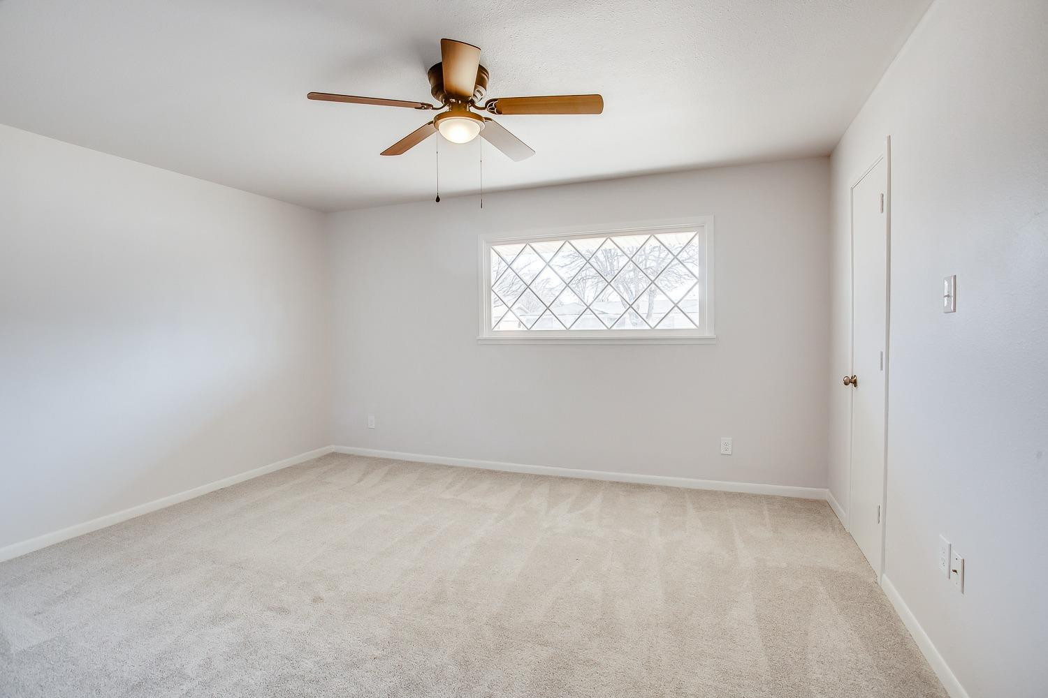 3410 53rd Street Lubbock, TX 79413 - Photo 8 of 14 an empty room with a window and a ceiling fan