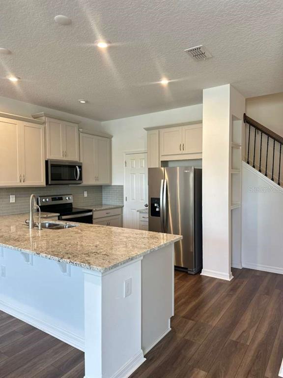 9031 Legado Drive Windermere, FL 34786 - Photo 11 of 27 a kitchen with stainless steel appliances granite countertop a refrigerator stove microwave and sink
