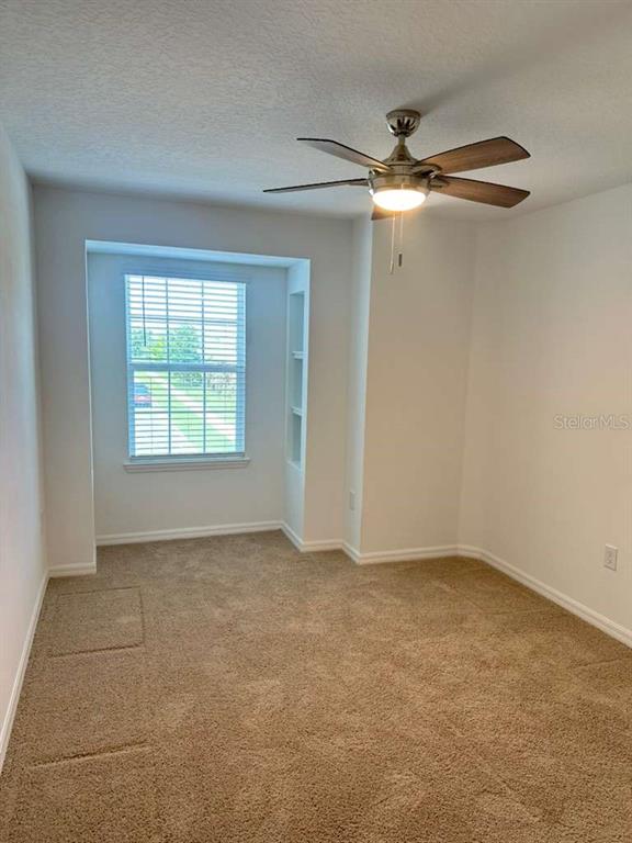 9031 Legado Drive Windermere, FL 34786 - Photo 16 of 27 an empty room with windows and fan