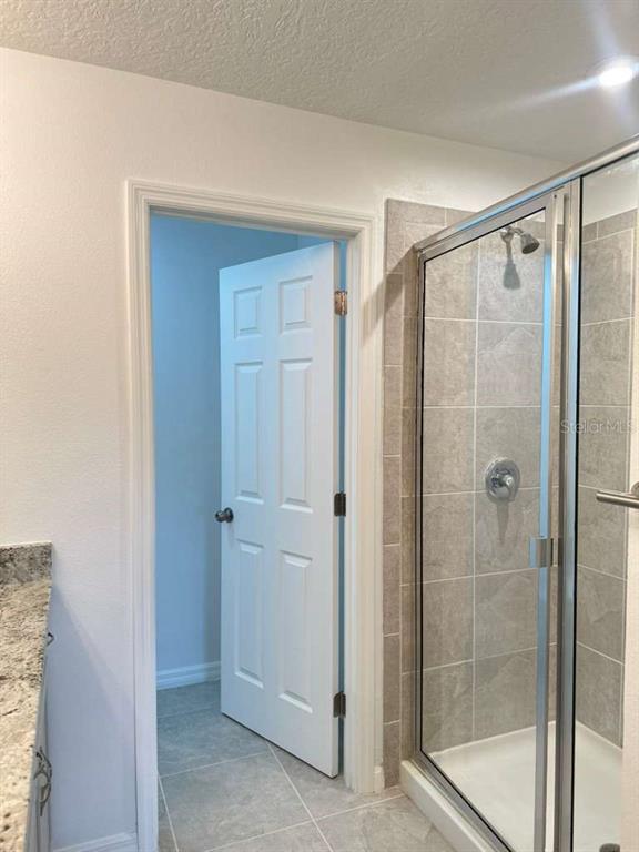 9031 Legado Drive Windermere, FL 34786 - Photo 20 of 27 a bathroom with a glass shower door