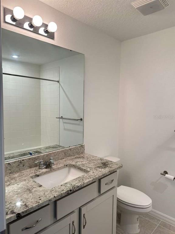 9031 Legado Drive Windermere, FL 34786 - Photo 21 of 27 a bathroom with a granite countertop sink and a toilet