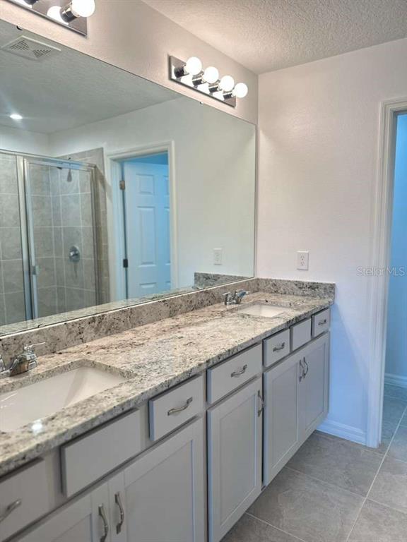 9031 Legado Drive Windermere, FL 34786 - Photo 23 of 27 a bathroom with a granite countertop sink and white cabinets