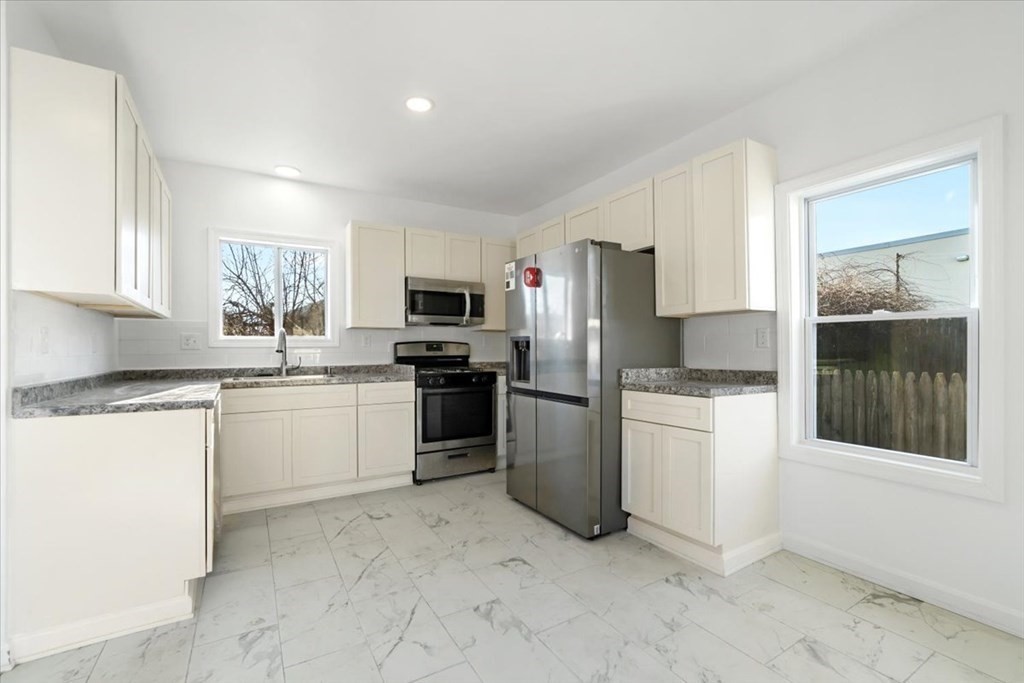 35 Russell Street Fall River, MA 02721 - Photo 8 of 27 a kitchen with a refrigerator and a stove top oven