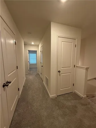 a view of a hallway with closet and wooden floor