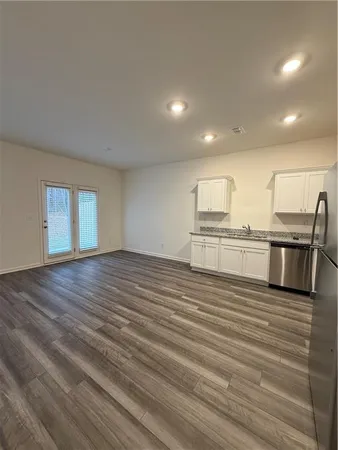 a view of kitchen with granite countertop stainless steel appliances and wooden floor
