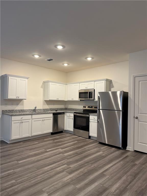 306 Rydal Way Winder, GA 30680 - Photo 5 of 19 a kitchen with stainless steel appliances wooden floor and a refrigerator
