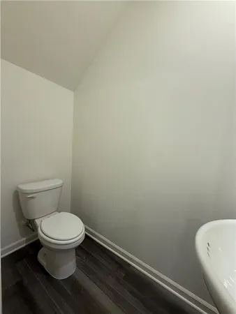 a white toilet sitting next to a white wall