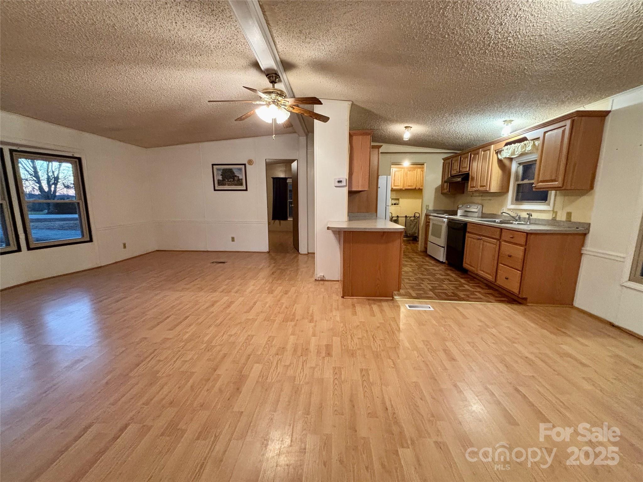 298 West B Phindeck Road Bostic, NC 28018 - Photo 10 of 34 a large hall with stainless steel appliances granite countertop a stove oven a refrigerator with the outer view and wooden floor