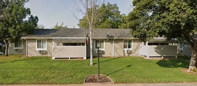 a white house that has a tree in front of it