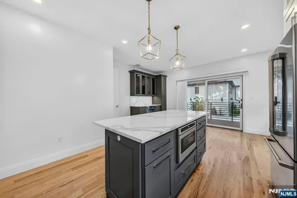 a kitchen with a stove and wooden floor