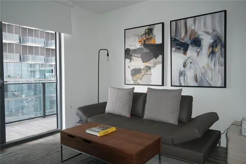 a living room with furniture and a painting on the wall