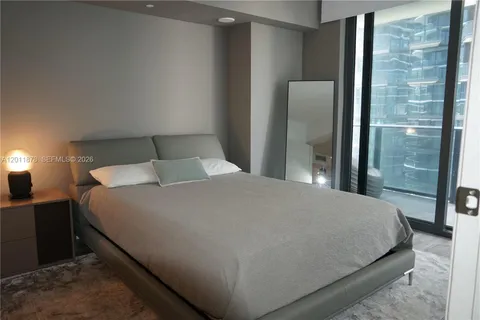 a large bed in a bedroom next to a window