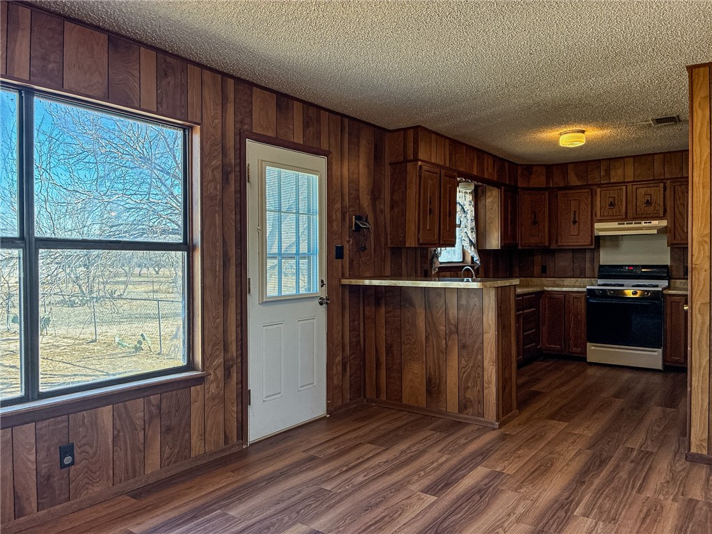 180 Recreation Road 8 Calliham, TX 78007 - Photo 8 of 17 a kitchen with granite countertop wooden floors stainless steel appliances a window and a sink