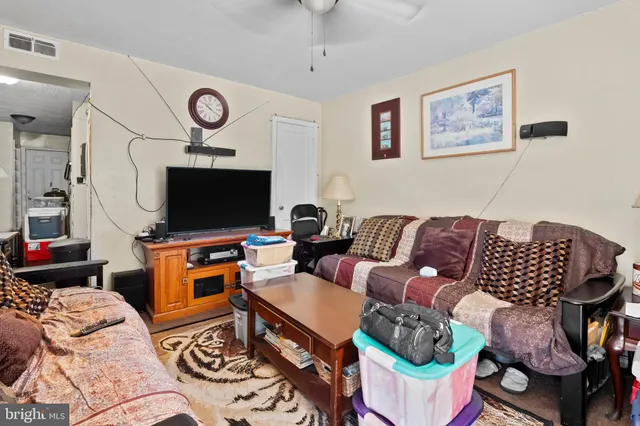a living room with furniture a flat screen tv and a wall painting