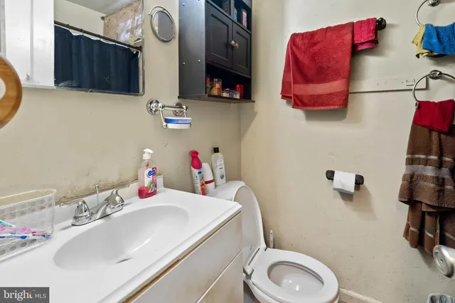 a bathroom with a sink vanity mirror and toilet