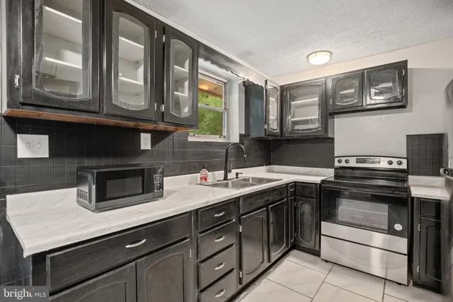 a kitchen with stainless steel appliances granite countertop a sink stove and cabinets