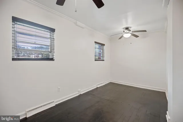 an empty room with a window and a fan