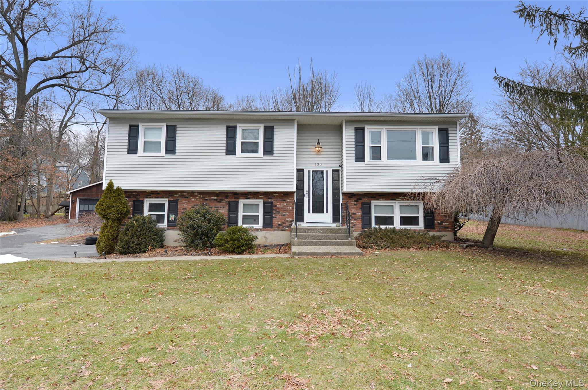 a view of a house with a yard patio and fire pit
