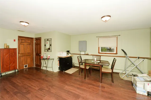 a living room with furniture a dining table and chairs with wooden floor