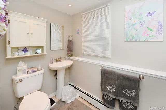 a bathroom with a toilet a sink and a mirror