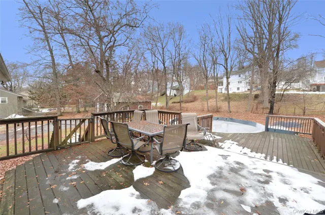 a view of a patio with table and chairs with wooden floor and fence