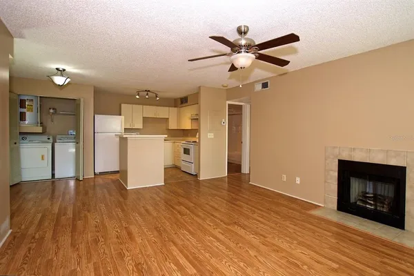 a view of a kitchen with wooden floor a ceiling fan and a kitchen view
