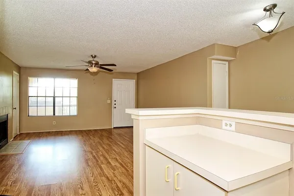 a view of a kitchen with wooden floor and a ceiling fan