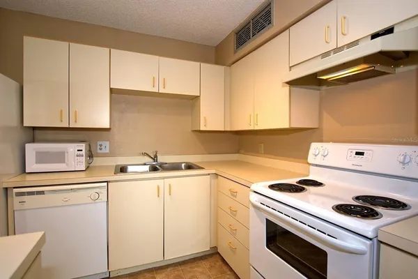 a kitchen with cabinets appliances a sink and a stove