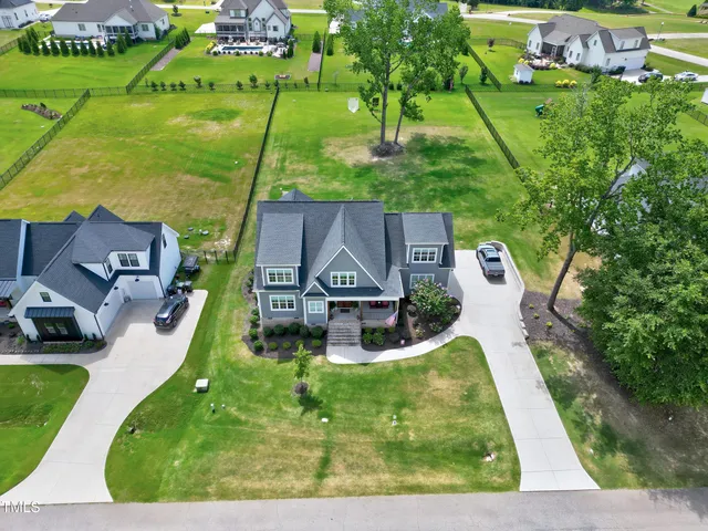 an aerial view of a house with a yard and lake view