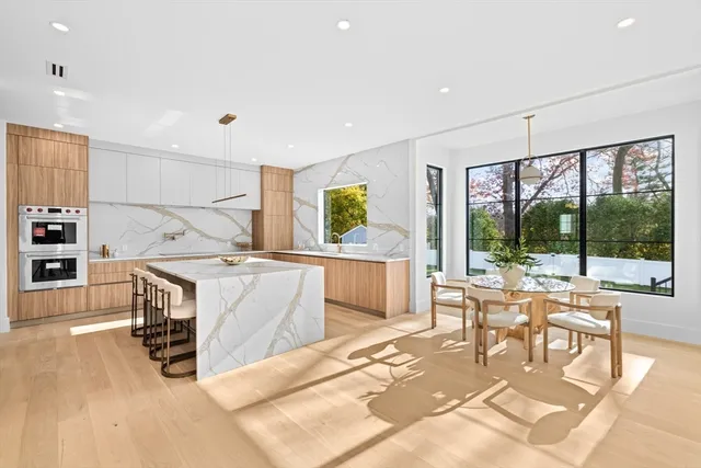 a living room with furniture a large window and dining table