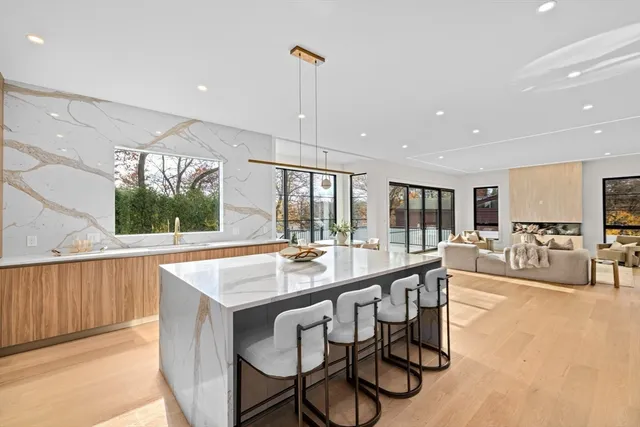 a large dining hall with stainless steel appliances granite countertop a stove and a wooden floors