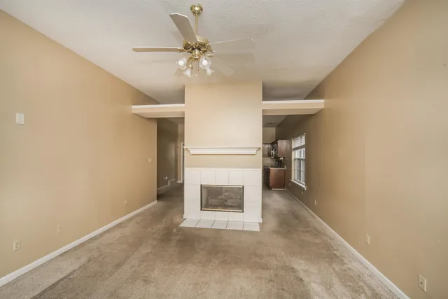a view of a hallway with wooden floor and a ceiling fan