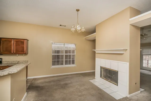 a view of an empty room with a fireplace and a window