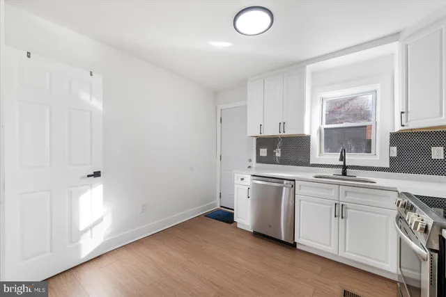 a kitchen with a sink cabinets and wooden floor