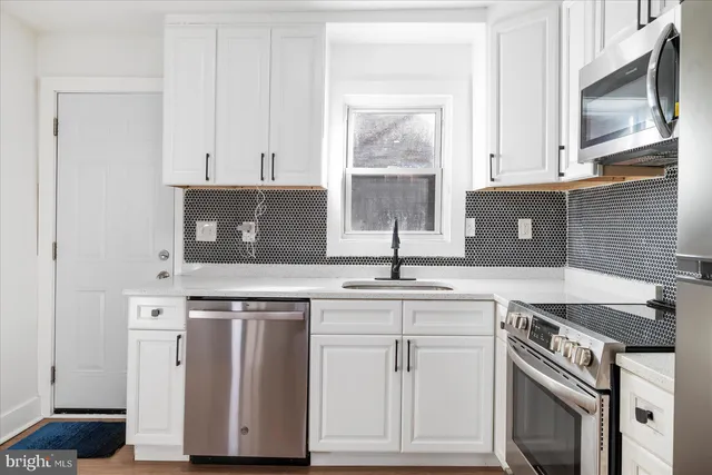 a kitchen with cabinets appliances and a sink