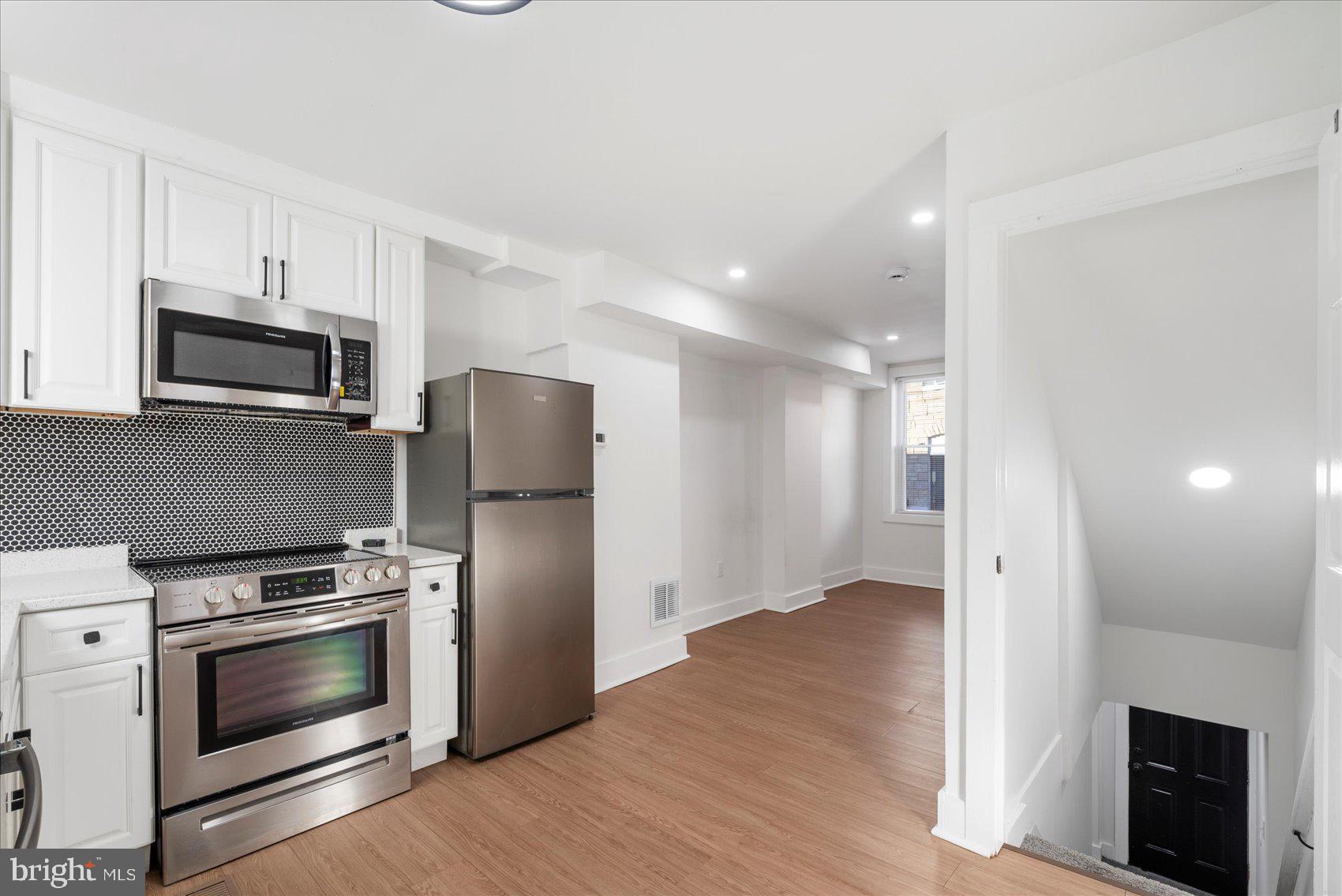 847 Reinhardt Street Baltimore, MD 21230 - Photo 13 of 41 a kitchen with a refrigerator stove and wooden floor