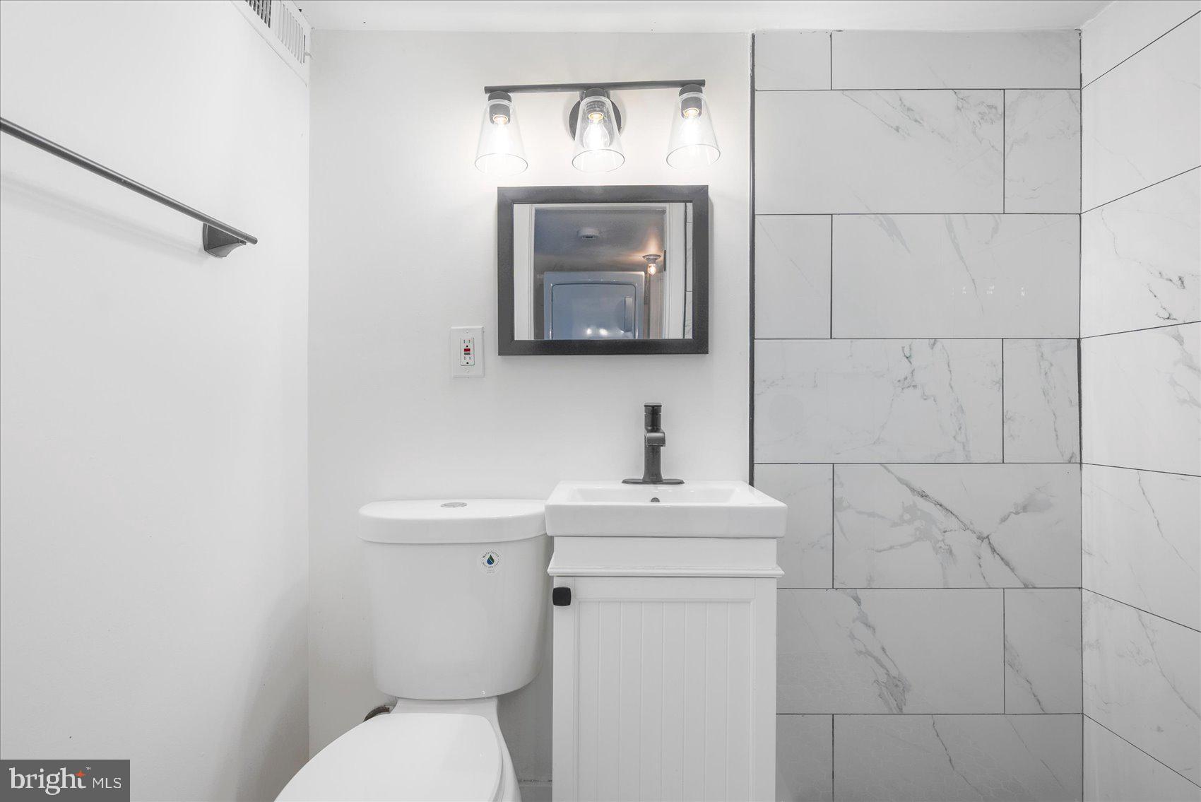 847 Reinhardt Street Baltimore, MD 21230 - Photo 30 of 41 a bathroom with a toilet sink and mirror