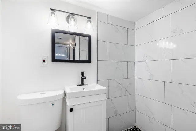 a bathroom with a toilet sink and mirror